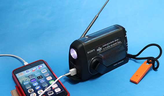 ICF-B300 で、手回しで内蔵バッテリーを充電して、iPhoneを充電しつつ、LEDライトをつけている ラジオはOFF